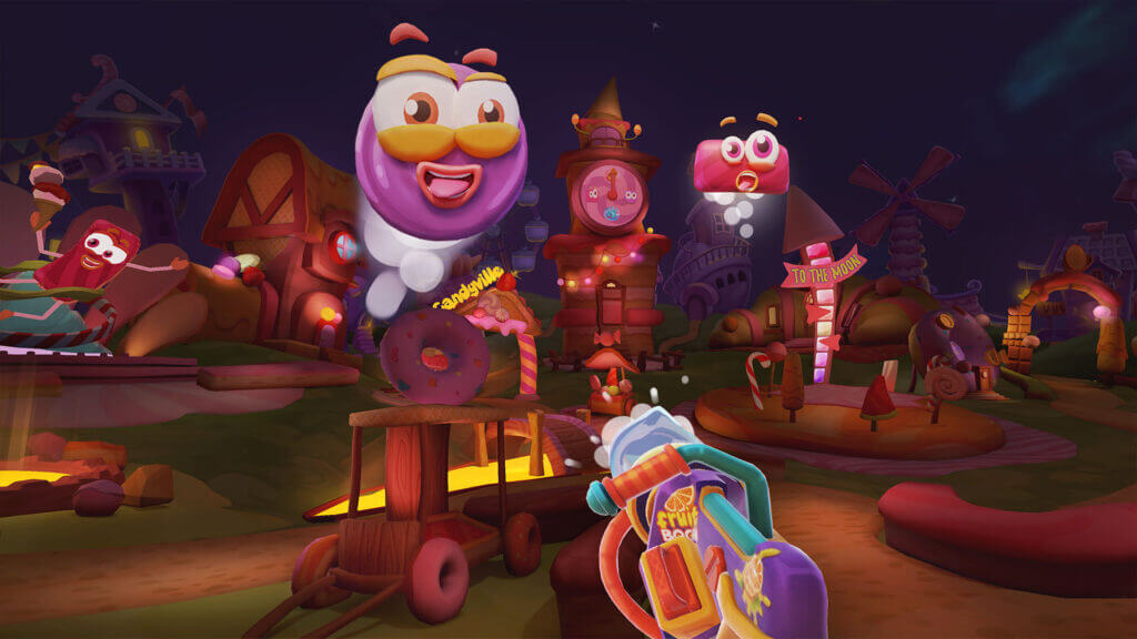 First-person view of the player aiming at floating candy characters in a dark, whimsical candy village at night.